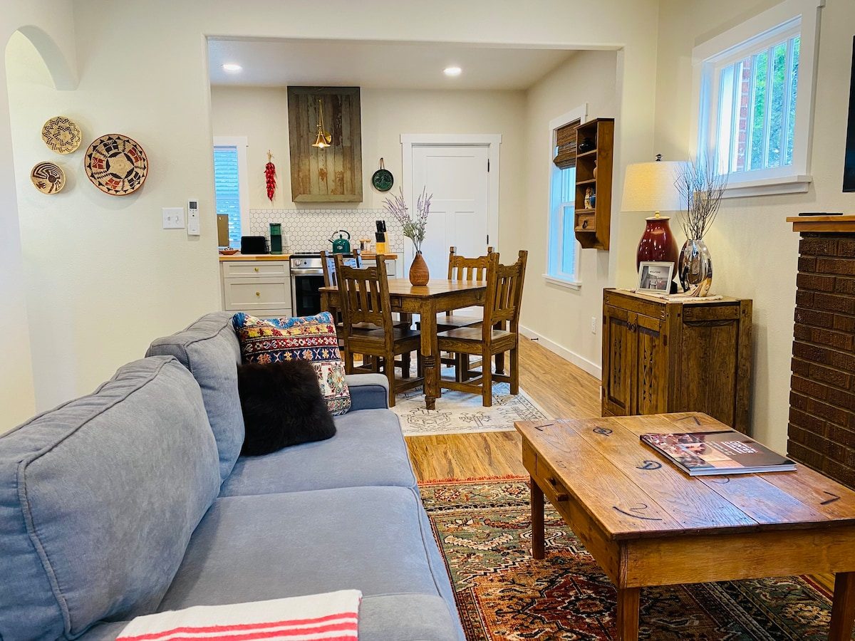 Living room with gray sofa, wooden coffee table and dining area beyond