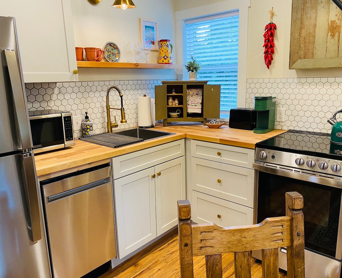 Kitchen with wood counters, stainless appliances and a string of red chiles