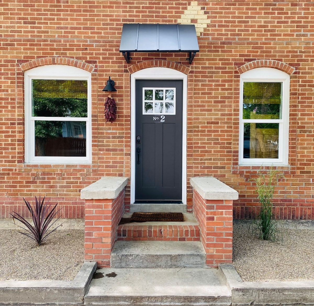 Casita front door with arched brick surround and stone steps