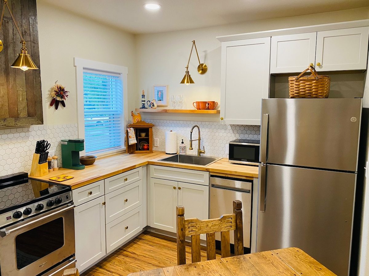Kitchen with wood counters, stainless appliances and open shelf