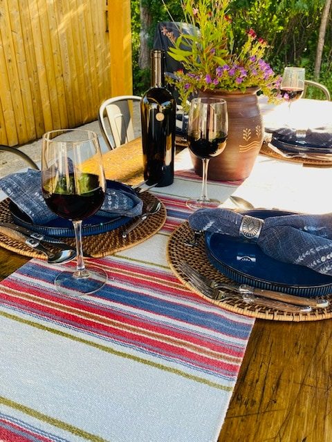 Table set with striped runner, plates and wine glasses