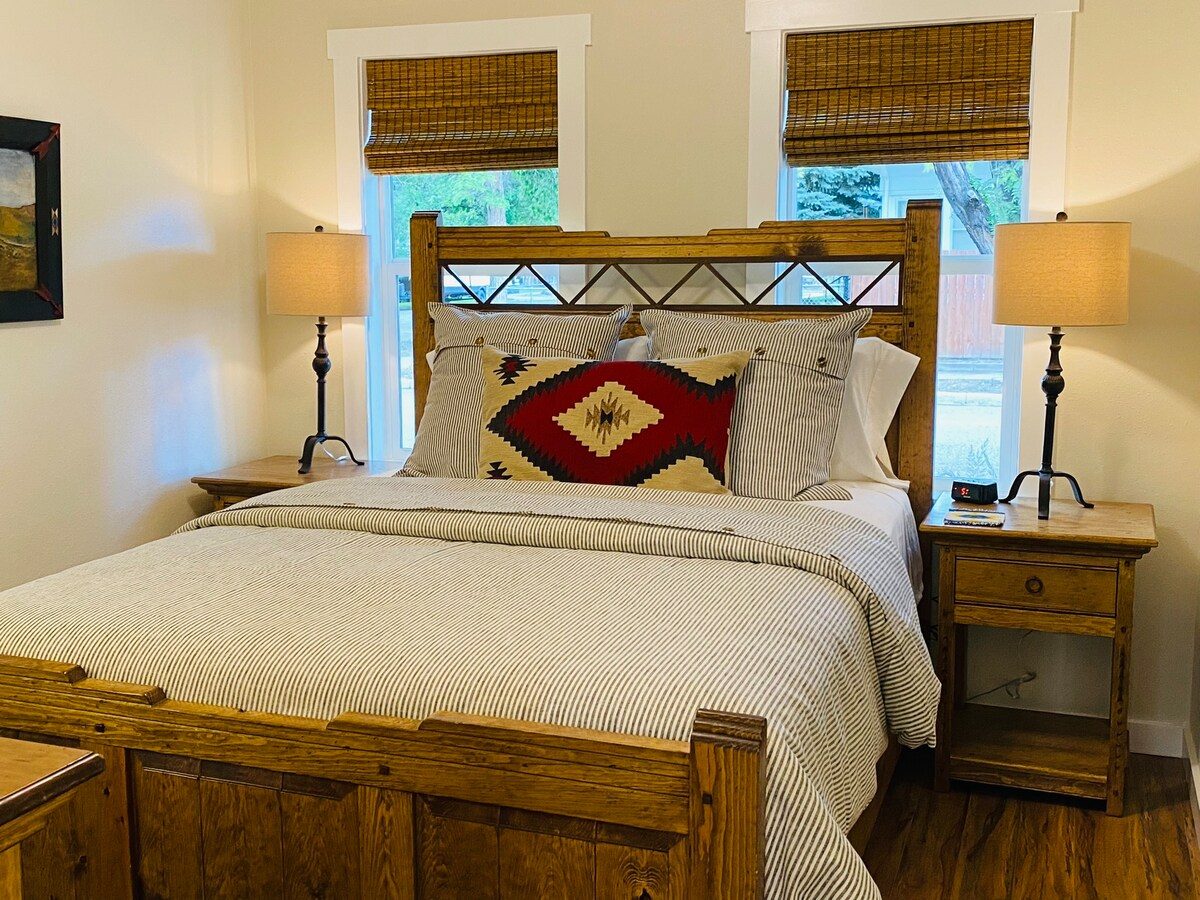 Bedroom with rustic wood bed and red diamond-pattern pillows