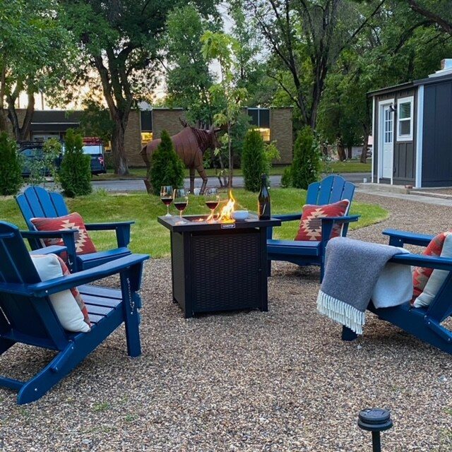 Fire pit with blue Adirondack chairs and gravel patio