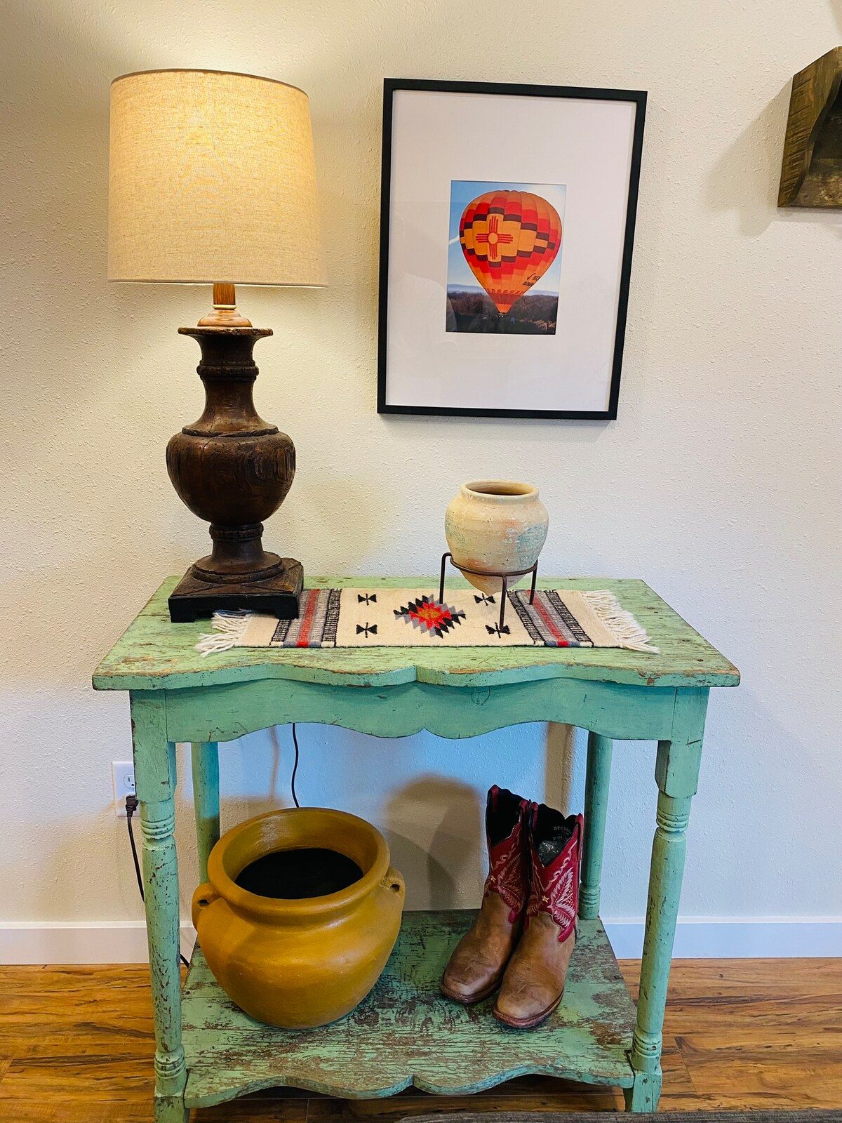 Turquoise console table with lamp, pottery and cowboy boots