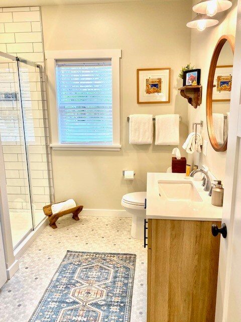 Bathroom with glass shower and a blue patterned rug