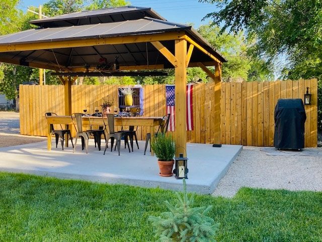Covered patio gazebo with dining table and grill